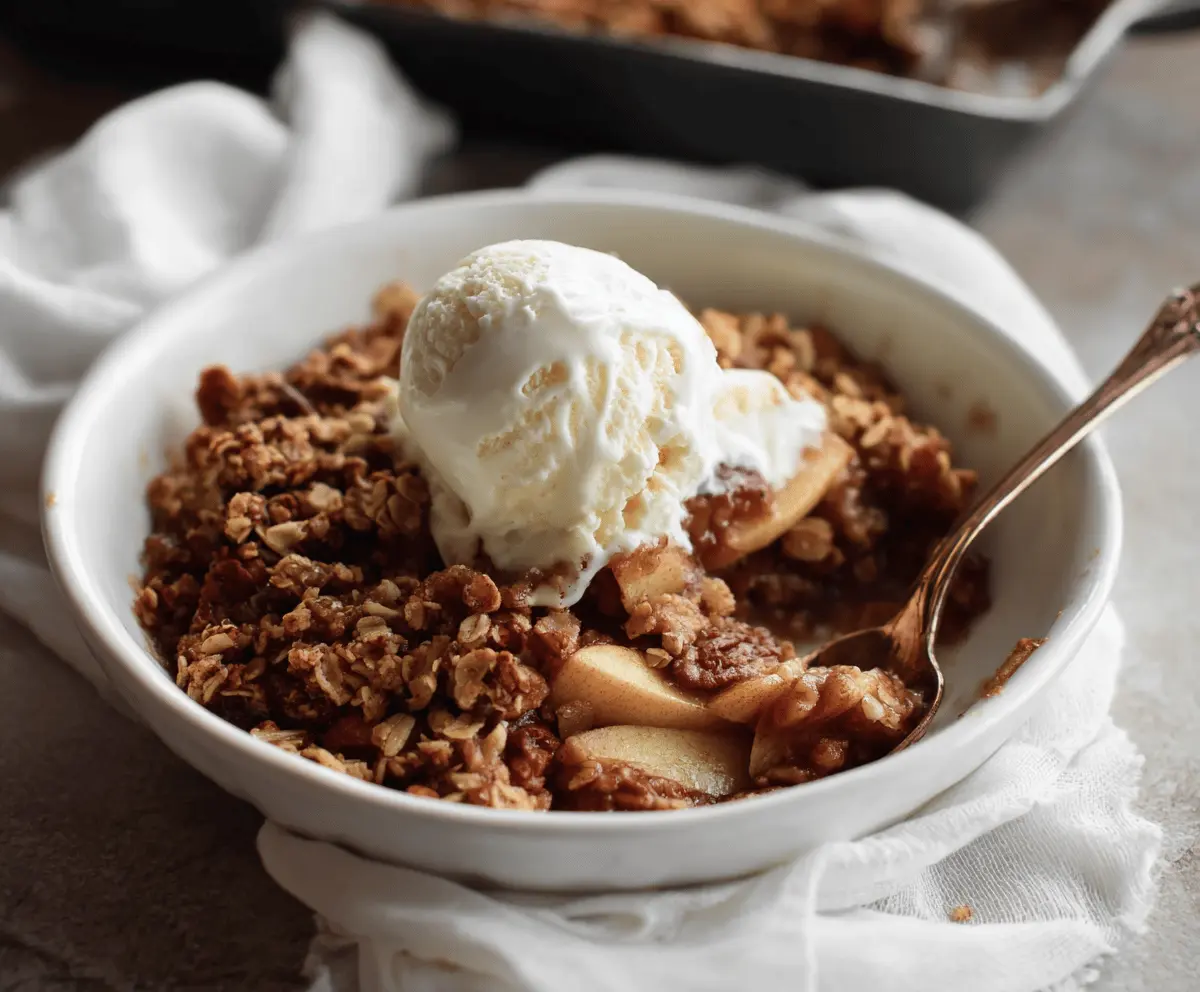 Delicious Maple Walnut Apple Crisp served in a bowl with fresh apple slices and a sprinkle of walnuts on top.