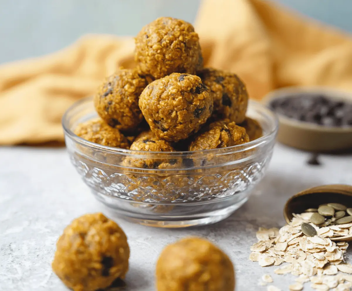 Healthy pumpkin banana protein balls on a white plate with ingredients in the background, perfect for a nutritious snack
