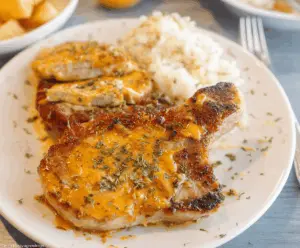 Delicious Cheddar Ranch Pork Chops served on a plate with fresh vegetables