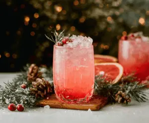 Festive Christmas Paloma cocktail in a glass, garnished with lime and cherry, perfect for holiday celebrations.