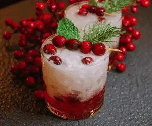 Festive Merry Mistletoe Cocktail in a glass garnished with merry decorations for holiday celebration