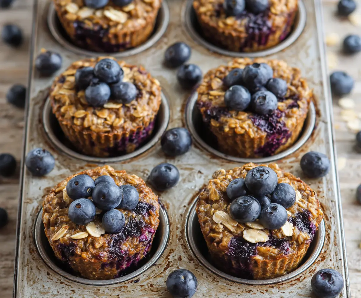 Healthy blueberry banana baked oatmeal cups in a muffin tin for breakfast meal prep