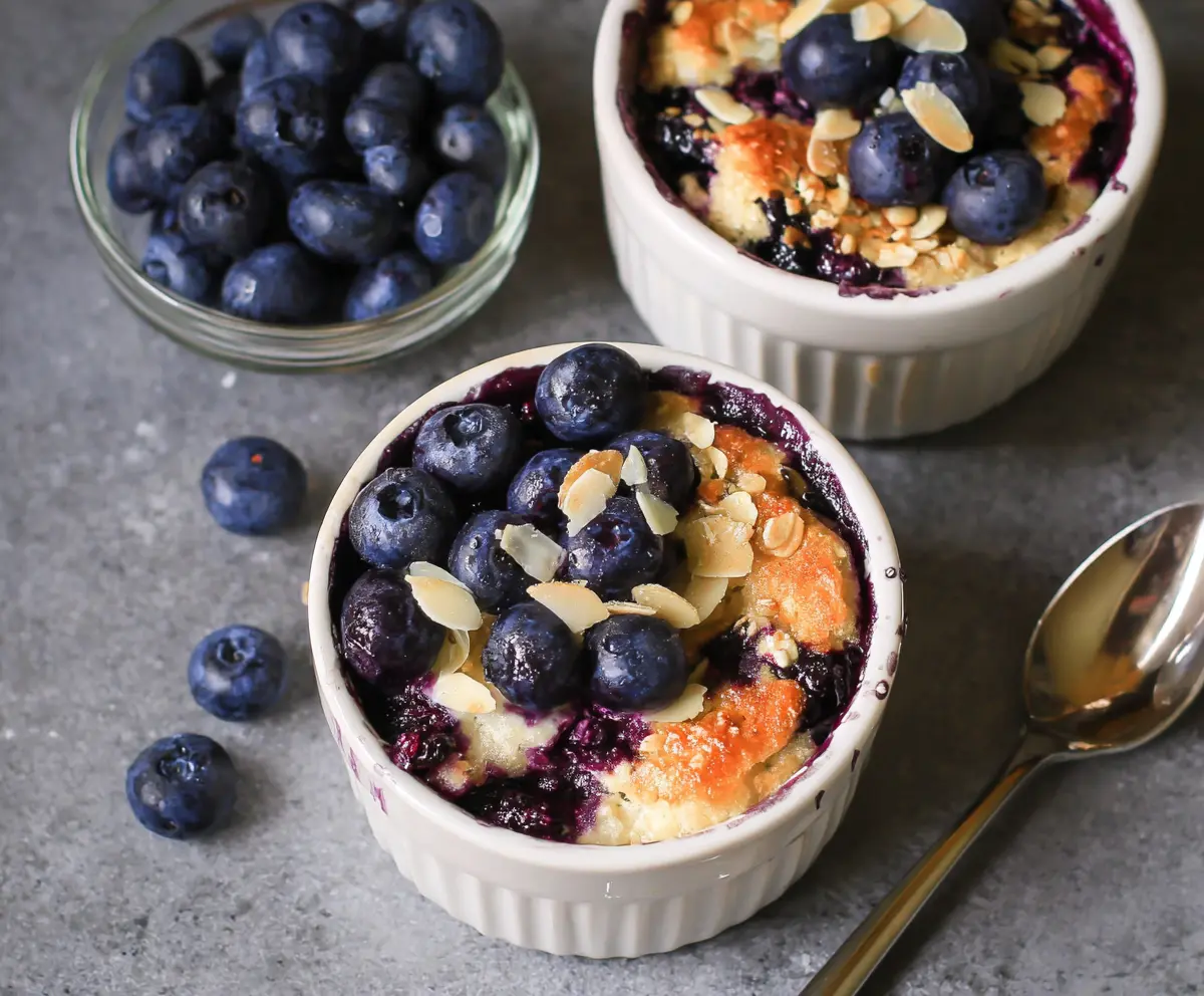 Healthy baked blueberry cottage cheese breakfast bowls served in a bowl, garnished with fresh blueberries and mint.