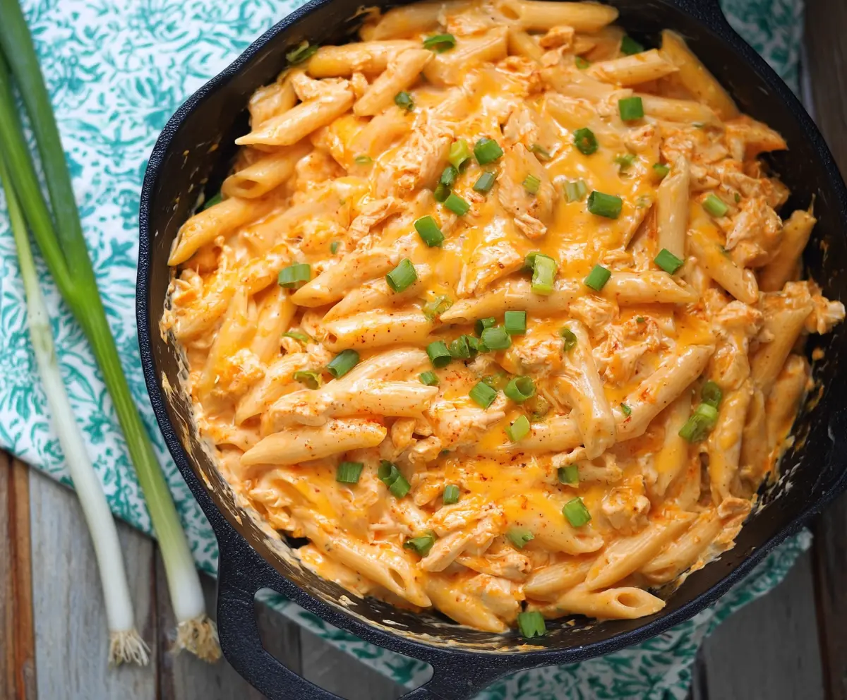 Creamy Buffalo Chicken Alfredo Penne pasta topped with crispy chicken pieces and fresh herbs.