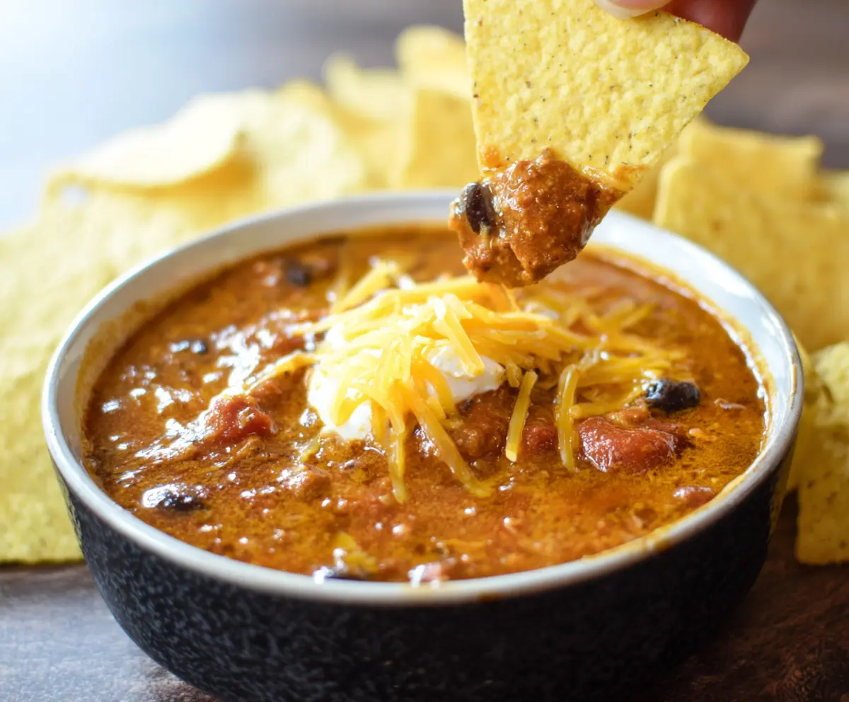 Delicious Crockpot Chili Cheese Dip served with crispy tortilla chips.