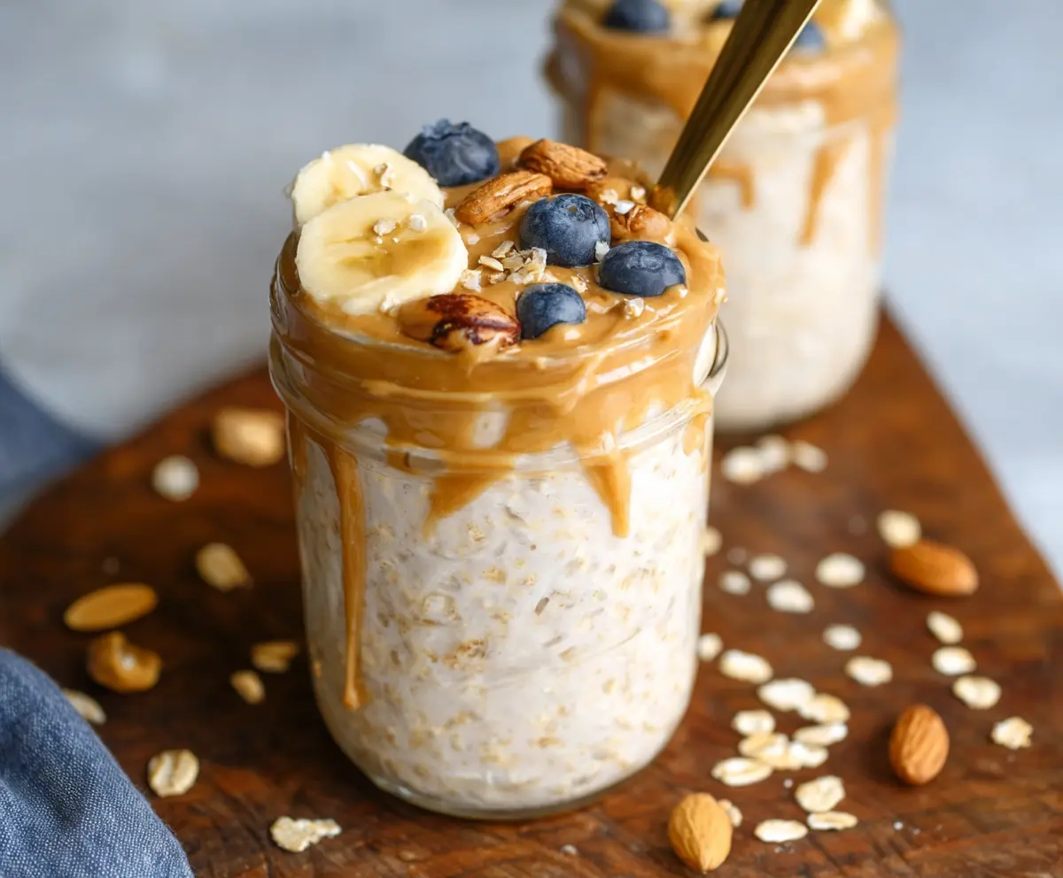 Creamy peanut butter overnight oats topped with fresh berries and honey in a glass jar.