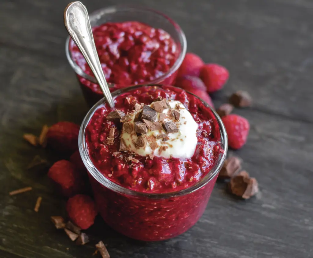 Delicious red velvet overnight oats topped with cream cheese and fresh berries for a nutritious breakfast.