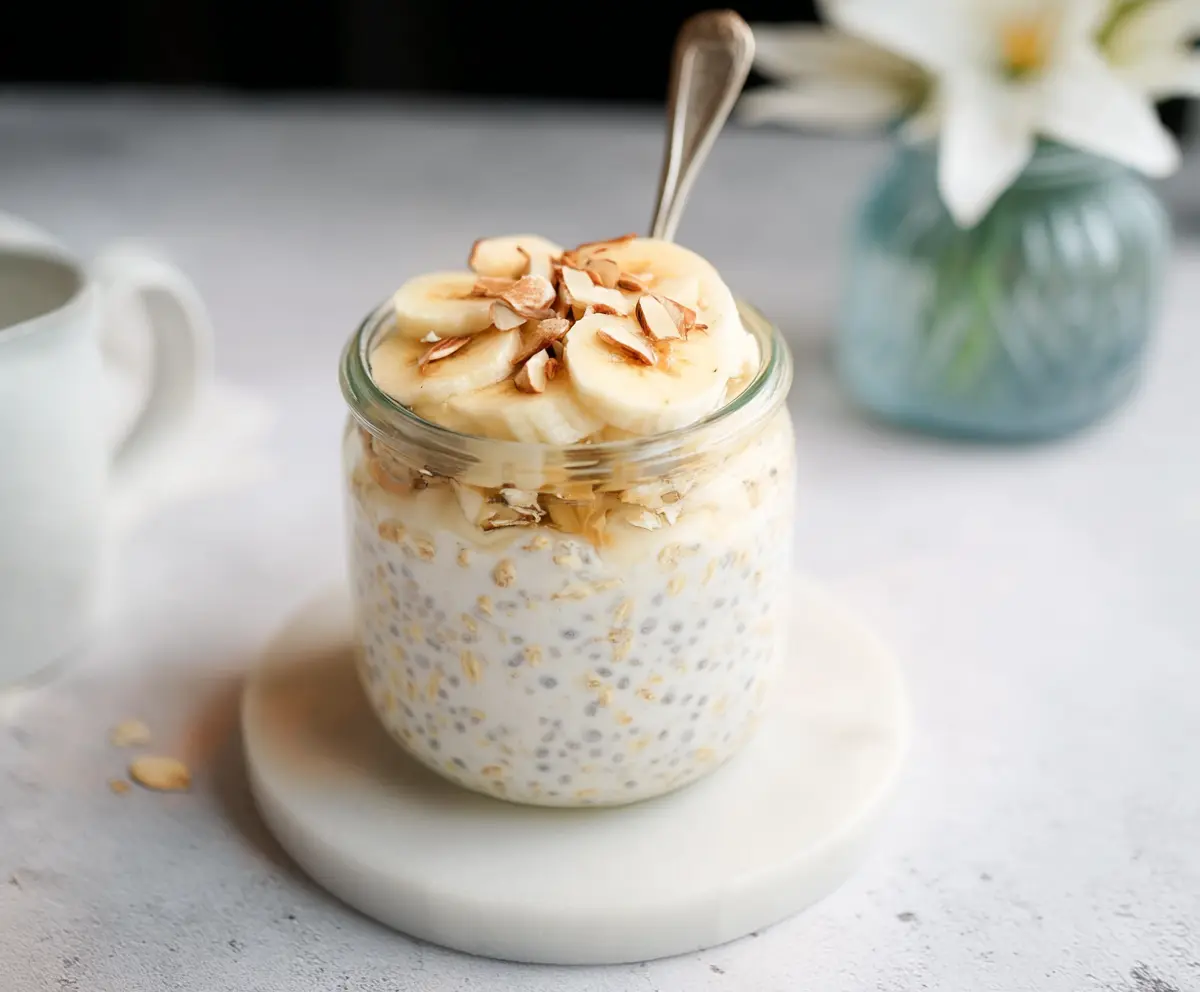 Creamy vanilla-flavored overnight oats in a glass jar with fresh fruit topping.