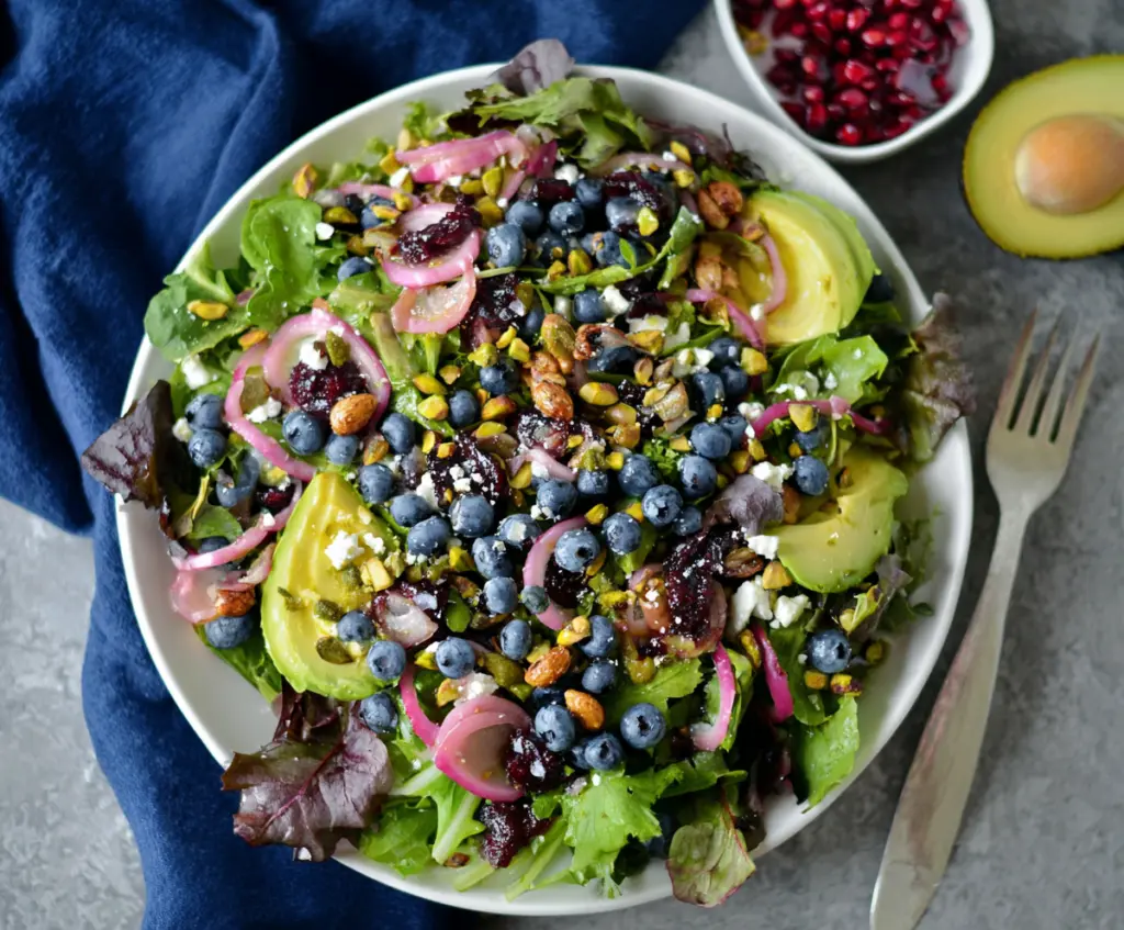 Fresh Blueberry Pistachio Spring Salad with vibrant greens and colorful toppings.