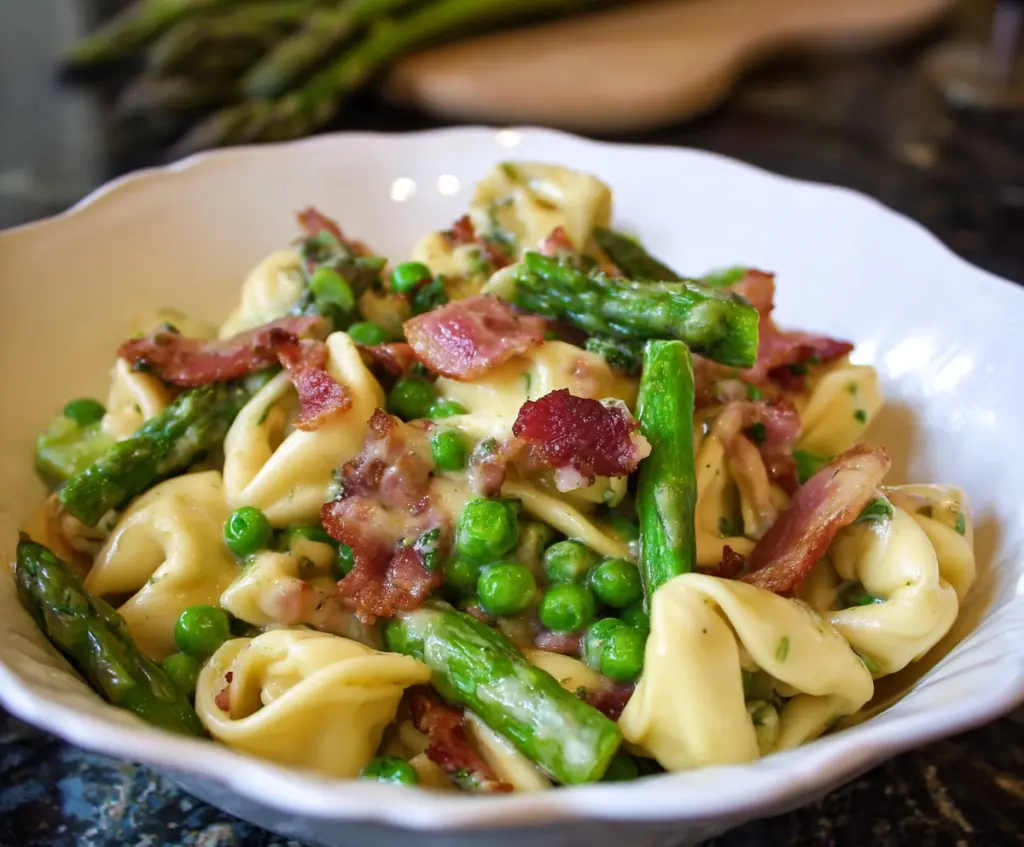 Delicious tortellini with peas, asparagus, and crispy bacon on a plate.