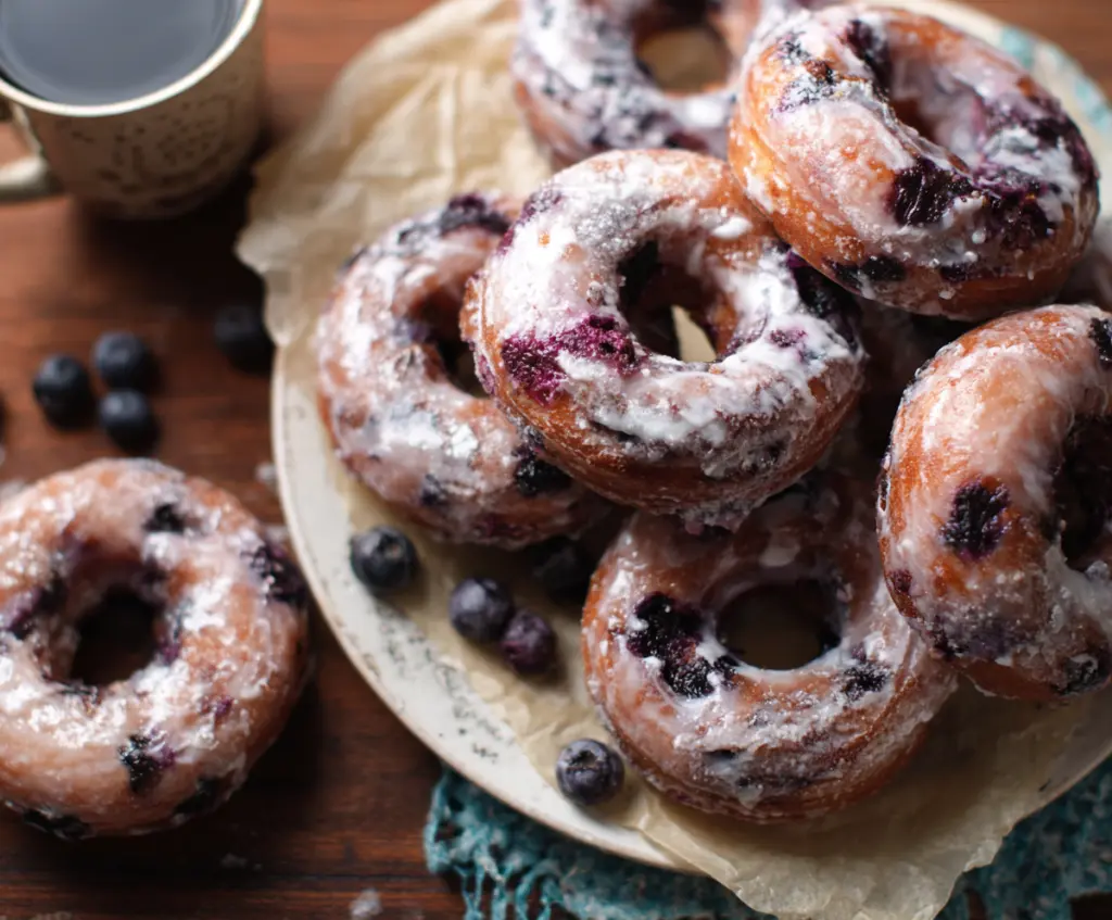 Delicious blueberry cake donuts topped with fresh blueberries and glaze.
