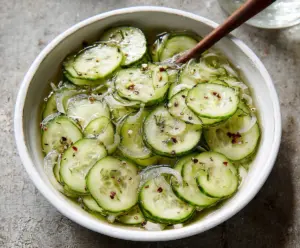 Fresh cucumber vinegar salad garnished with herbs, perfect for a light and tangy appetizer.