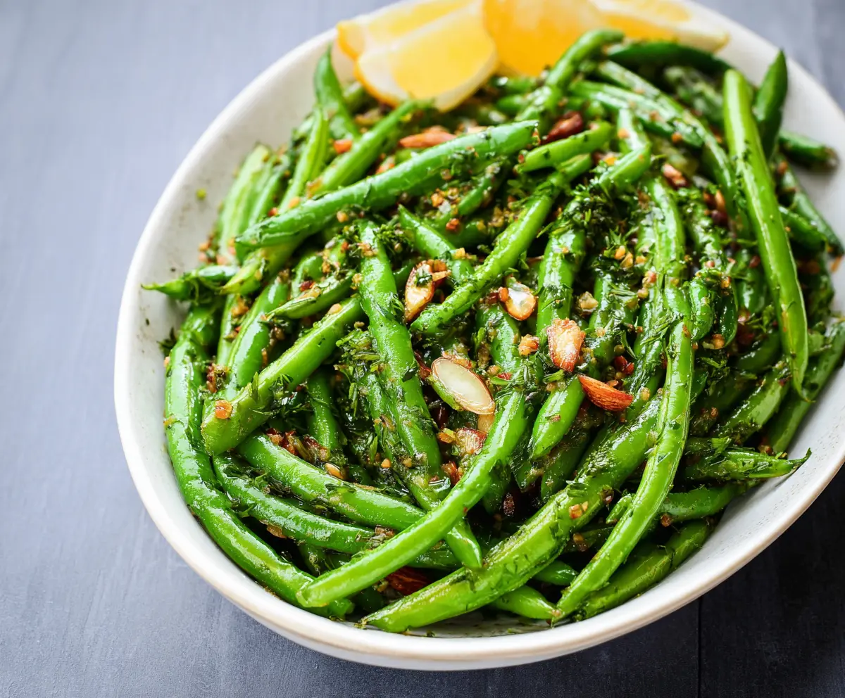 Delicious Dijon Green Beans garnished with herbs, perfect as a healthy side dish.