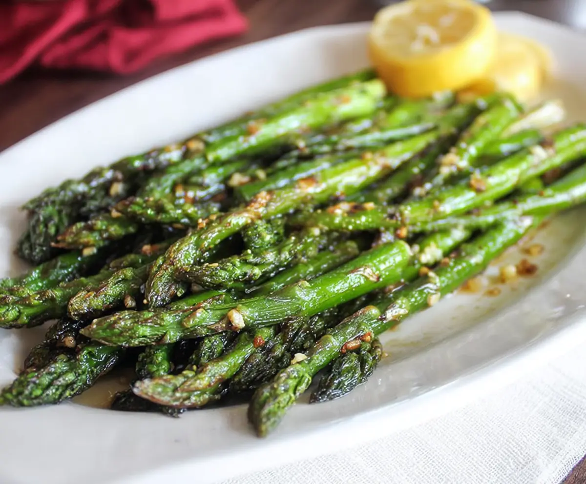 Delicious garlic butter roasted asparagus on a white plate