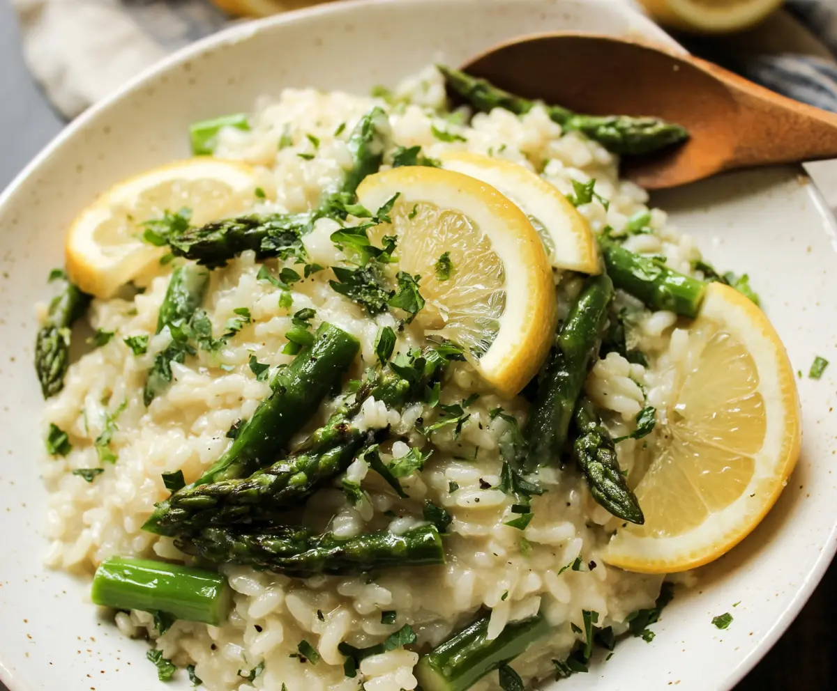 Creamy lemon asparagus risotto served in a bowl, garnished with fresh herbs.