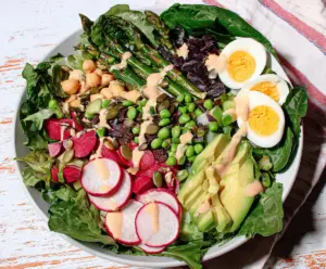 Fresh spring chopped salad with vibrant vegetables and herbs, perfect for a light healthy meal.