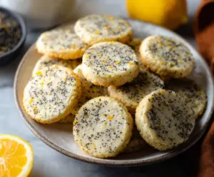 Golden Lemon Poppy Seed Cookies on a white plate, garnished with lemon zest.