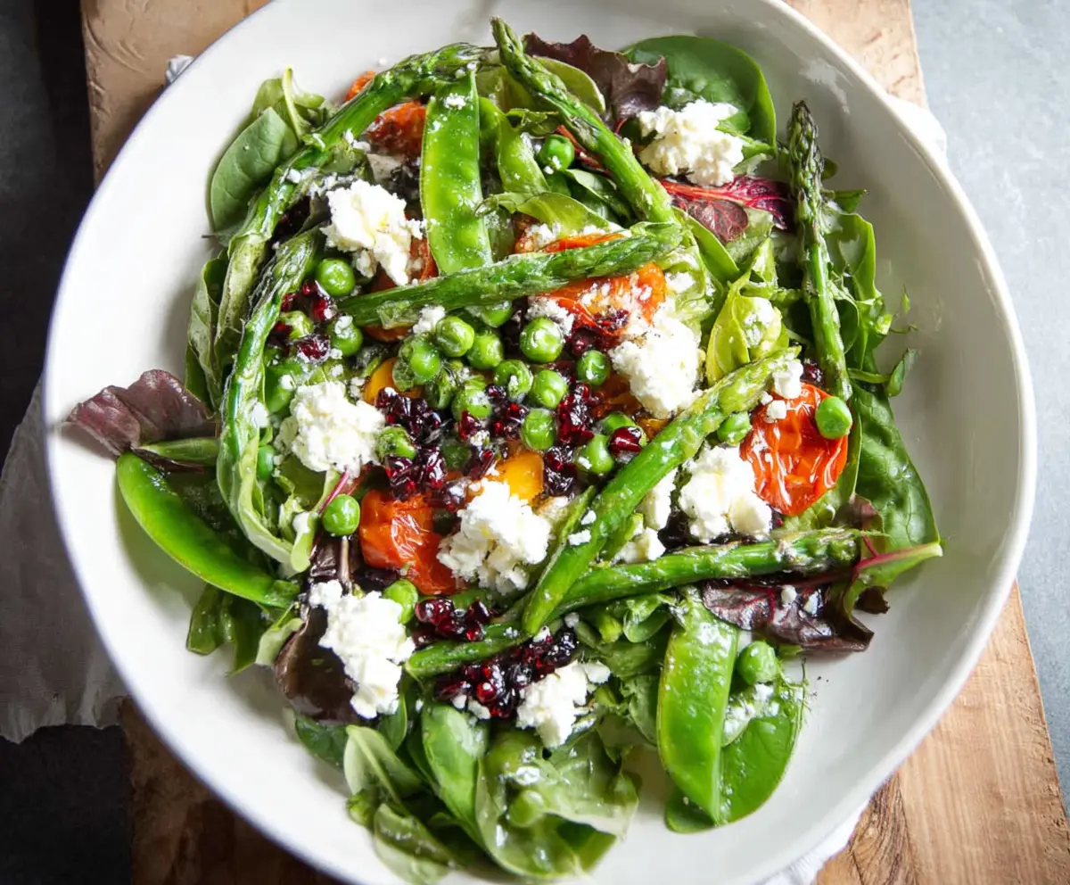Fresh spring salad with goat cheese, mixed greens, strawberries, and walnuts in a light vinaigrette.
